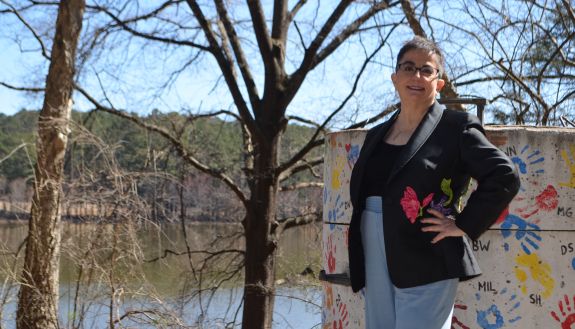 Woman standing next to neurodiversity painted sign