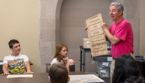 Durham middle school students become historian adventurers during the John Hope Franklin Young Scholars one-week immersion program, sponsored by Duke Community Affairs and the Provost’s Office. During a session in Rubenstein Library, DCA’s David Stein, senior education partnership coordinator, discusses items from the archives with the students. Th