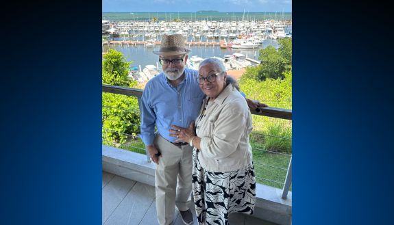 A man and woman stand in front of a marina