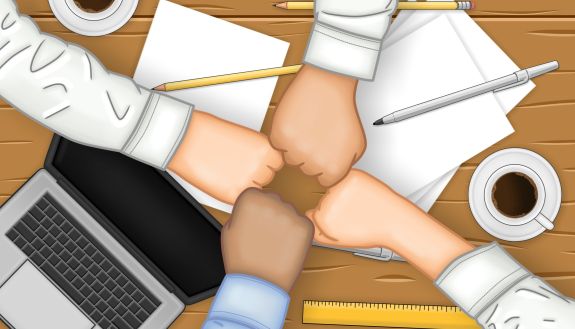 Fists bumping over a desk