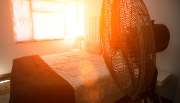 image of bedroom during severe heat, fan blowing