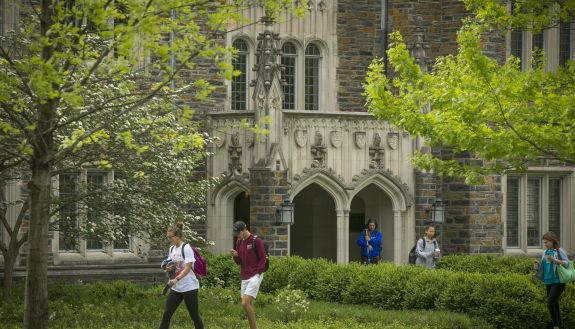 Person walking along a building on campus