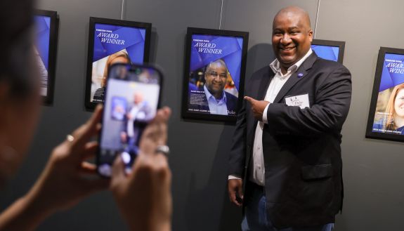 Person pointing to their award poster