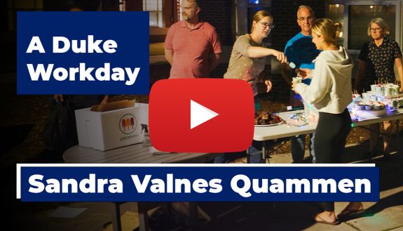 Sandra Valnes Quammen hands out snacks to students outside Blackwell Residence Hall.