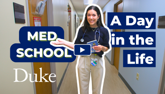 Woman stands in a hallway with a stethoscope around her neck. Words on screen: "A Day in the Life Med School" and the Duke logo
