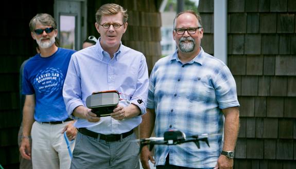 President Vincent Price directs a drone during a visit to the Marine Lab. Professor David Johnston, right, who uses drones to study marine mammals, watches. Photo Jared Lazarus