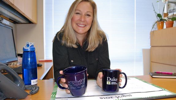 Katie Kross, managing director for the Center for Energy, Development and the Global Environment, shows off the two mugs she uses in the office. Photo by Stephen Schramm.