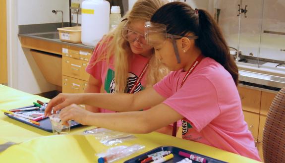 Elizabeth Owens, left, and a fellow camper take part in an experiment at ACTION Science Camp for Young Women.