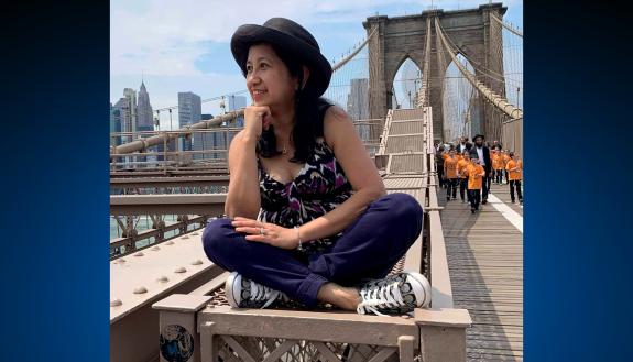 April Ferido poses on a railing in the middle of the Brooklyn Bridge. Photo courtesy of April Ferido.
