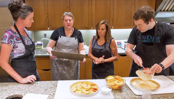 Nicole Schramm-Sapyta, far left, and Duke Institute for Brain Sciences team members cook together at Southern Season.
