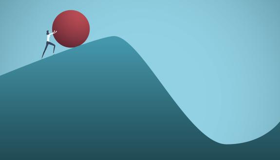 A woman pushes a boulder up a hill.