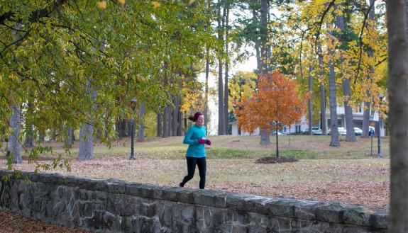 A runner jogs along the East Campus wall.