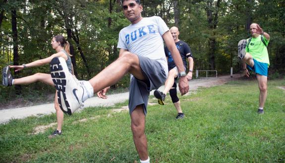 Employees with the Duke Run/Walk Club stretch before a run on the Al Buehler Trail. Photos by Les Todd.