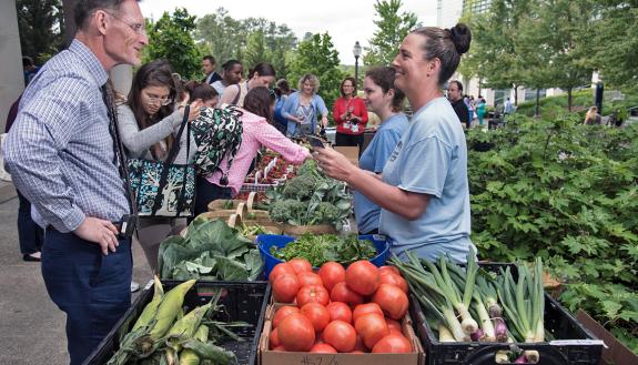 A customer shops at the Lyon Farms stand at Duke Farmers Market. Photo by Les Todd.