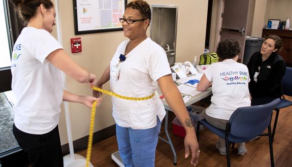 Victoria Hall, left, a certified medical assistant, measures Elizabeth Street’s waist size during a health assessment at Duke Regional Hospital. Photo by Les Todd.