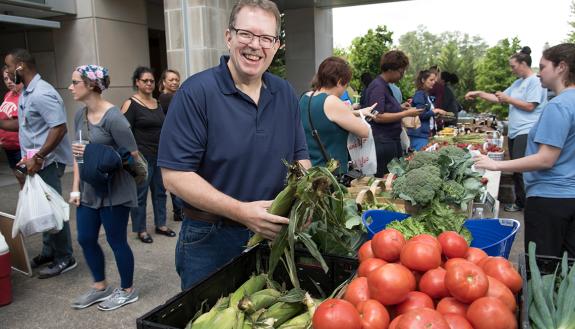 John Ervin shops at the Lyon Farms stand at Duke Farmers Market. Photo by Les Todd.