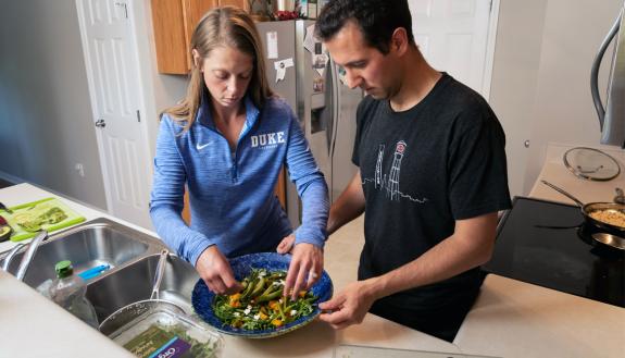 Morgan Heisman, left, and Evan Heisman, right, prepare a salad at their home in Durham. Photos by Les Todd.