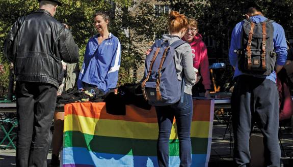 Guests pick up T-shirts from the Center for Sexual and Gender Diversity at the National Coming Out Day celebration on Bryan Center Plaza in 2019. Photo by Justin Cook.