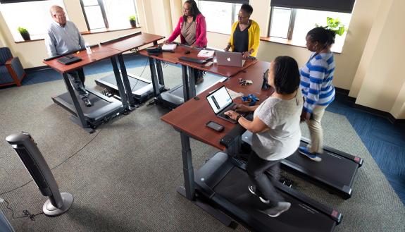 Staff from the School of Nursing’s information technology department meet in the school’s treadmill conference room. Photos by Les Todd. 