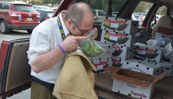 Eric Lipp, a senior clinical research coordinator for The Preston Robert Tisch Brain Tumor Center, smells a bag of tatsoi, a leafy green vegetable. Lipp has subscribed to Coon Rock Farm’s CSA through the Duke Mobile Farmers Market for about five years.