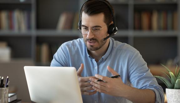 A man talks on his computer.