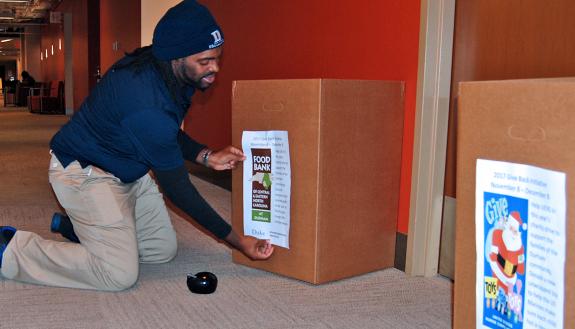 Facilities Management Department staff member Wayne Oatis sets up a donation box in Perkins Library.