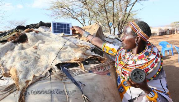 Winning photo from Africa image contest shows Katelina Lekanta, a pastoralist from Samburu in northern Kenya, connects her bluetooth radio to a solar panel for recharge on top of her manyatta,