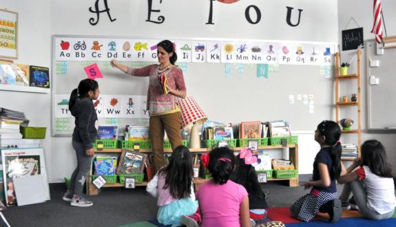 George Watts teacher Carolina Musawwir works with Afterschool Reading Academy students on Spanish vowel sounds.