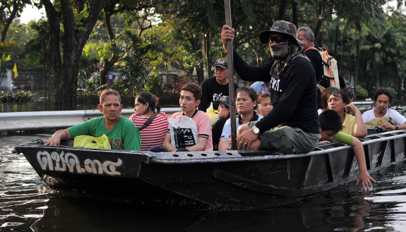 An army boat ferries flood victims to safety on a flooded road in Pinklao district, Bangkok, Thailand on November 4, 2011.