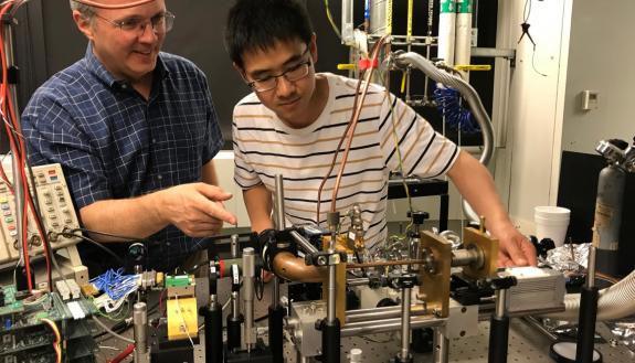 Duke professor Henry Everitt and then MIT graduate student Fan Wang with the first version of a tunable terahertz laser. Everitt's "copper pipe" can be seen in the center front. The group published this first prototype in 2019. (Photo courtesy of Harvard