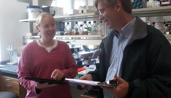 Randy Smith, departmental manager in the Department of Biology, and Debra Murray, a research scientist in the department, work through a checklist of items involved in Green Lab Certification. The pair have been taking part in the “Battle of the School