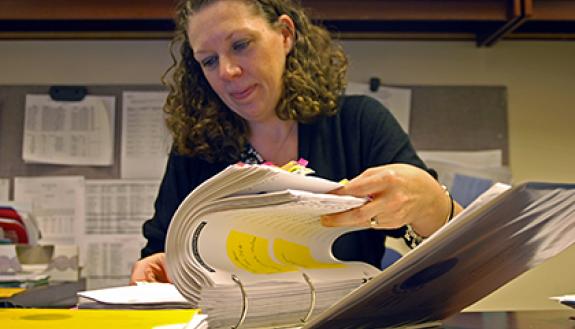 Melissa Sykes Palmer frequently checks the three-inch binder from her Duke Research Administration Academy program to remind her of the correct practices and procedures for administering grants. Photo by Marsha A. Green.
