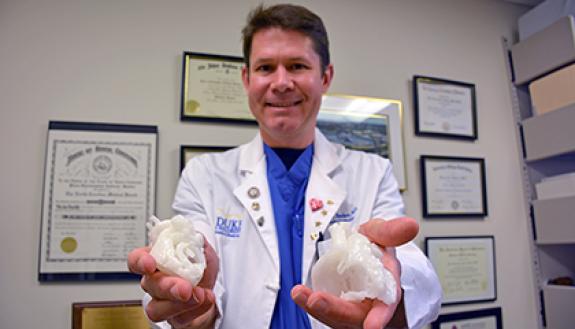 Dr. Piers Barker holds up 3D-printed replicas of hearts he created at the Innovation Studio. The printouts have helped him and colleagues better prepare for treatment of patients. Photo by Bryan Roth.