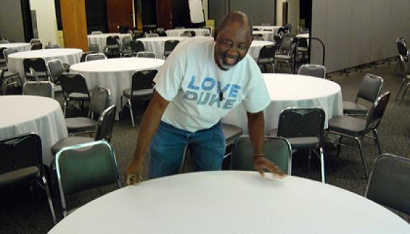 Carl Boler puts the finishing touches on arrangements for an event in the Von Canon room of the Bryan Center.