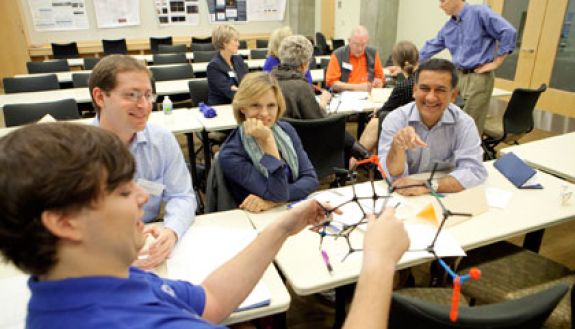 During one morning session, Duke chemistry Professor Steve Craig (in back in blue shirt) showed visitors how students can use a hands-on approach in science education.  Photo by Les Todd/Duke University Photography.