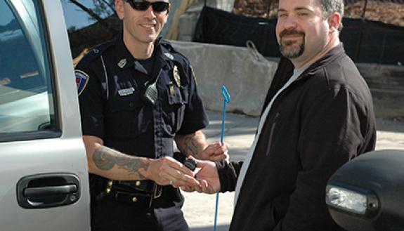 Duke lab assistant Shawn Johnson, right, serves as a Facility Watch coordinator for his building, Medical Sciences Research Building II, and is an alumnus of the Duke Police Citizens' Police Academy. In this photo, he poses as a locked-out motorist recei