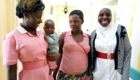 Baby Nathaniel at his three-month checkup with his mother (center) and two of his nurses. Survival odds were stacked against Nathaniel, who was born with gastroschisis.