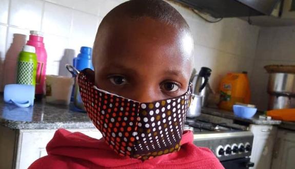 A pediatric oncology patient at Bugando Medical Centre wears a COVID-19 mask made of kitenge fabric. (Photo courtesy of Kristin Schroeder)