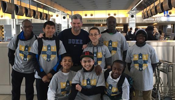 Eight boys from the Durham Nativity School pose with DGHI professor Michael Haglund at the Raleigh-Durham Airport on their way to Kampala, Uganda.