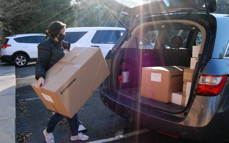 Karen Jackson of the Duke University School of Nursing loads boxes of face masks for colleagues into her car last week. Photo by Stephen Schramm.