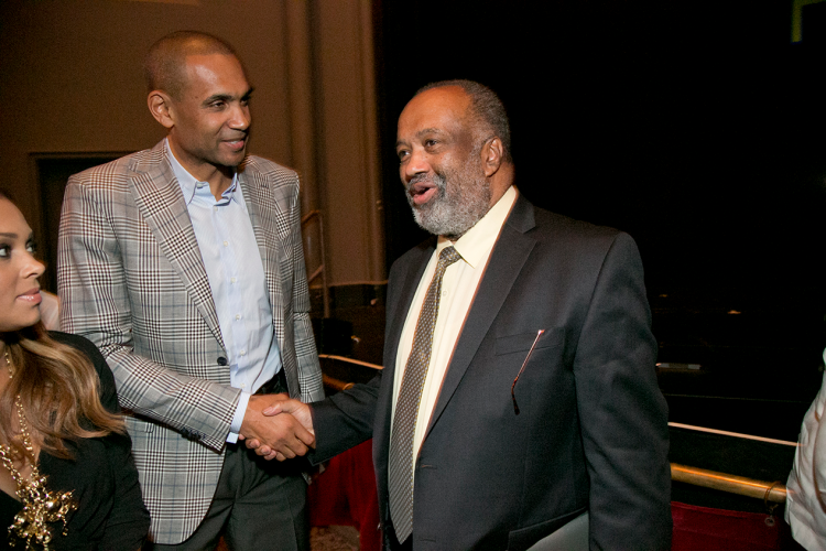 Nathaniel White shakes hands with Grant Hill at the 50th anniversary celebration.