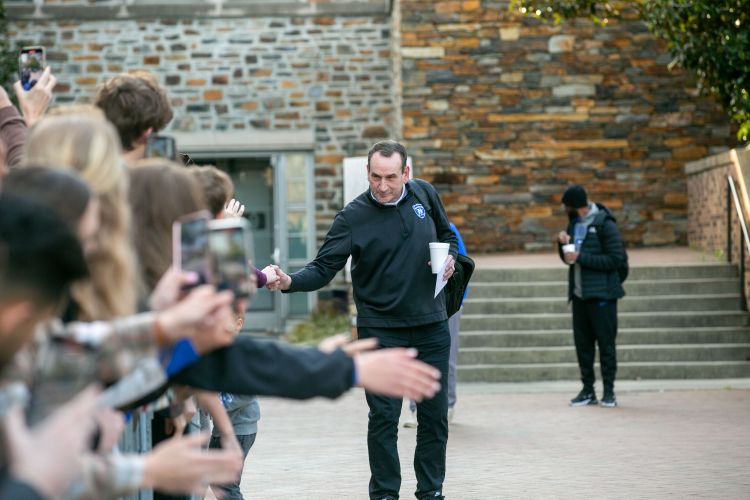 Coach K hold the hand of a fan as he leaves for the Final Four one last time