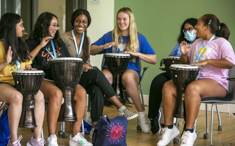 Duke first-year students in Project Wellness participate in a drum circle activity designed to make them feel comfortable expressing themselves and bond together in the Student Wellness Center. (Jared Lazarus/University Communications)