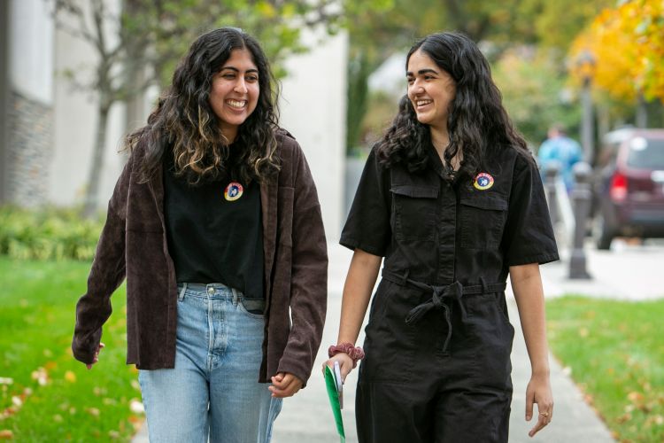 juniors Malika Rawal, left, and Reah Syed leave the Karsh Alumni and Visitors Center with their “No Bull I Voted stickers,” after casting their votes.