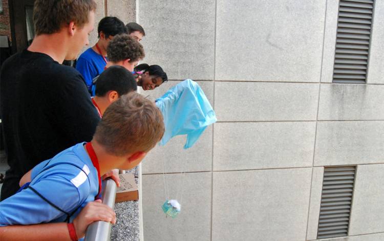 Campers drop eggs from a balcony as part of an activity for the Duke Biosciences & Engineering Camp. Photo by Stephen Schramm.