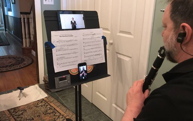 Nicholas Bandarenko records himself playing the clarinet while watching a recording of Verena Mösenbichler-Bryant conducting. Photo courtesy of Nicholas Bandarenko.