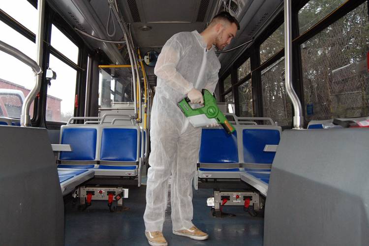 Luke Fenlon of Cenplex Building Services disinfects a Duke bus. Photo by Stephen Schramm.