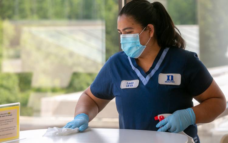 Duke Housekeeper Laura Valdovinos cleans surfaces at the Fuqua School of Business.