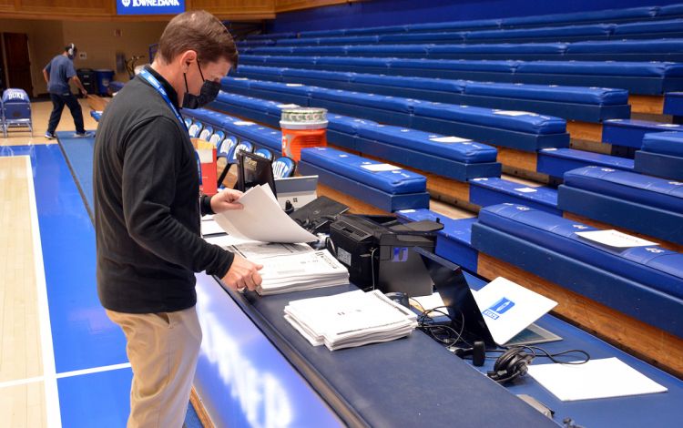 Lindy Brown prepares game notes around three hours before tip-off. Photo by Stephen Schramm.