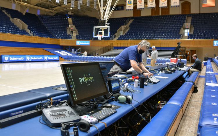 Mark Kitchens, the supervisor for Technical Services with University Center Activities & Events, sets up the scorers' table. Photo by Stephen Schramm.